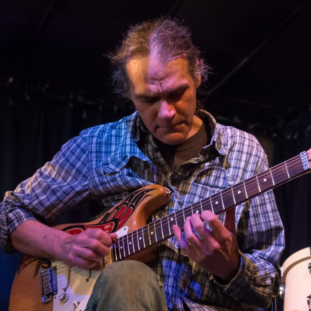 Photo of Tony Wilson playing guitar